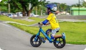 Bilde av liten gutt med sykkel på en bane